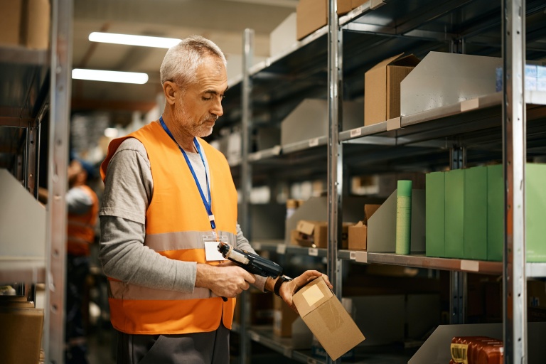 A man scans a package with a barcode scanner.